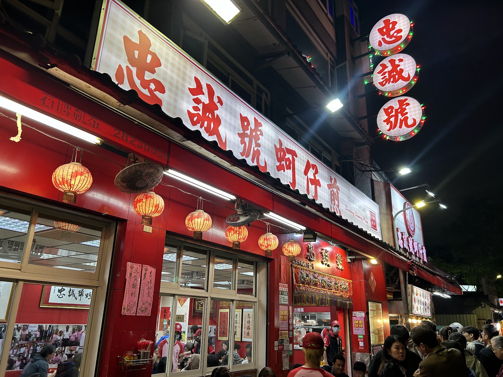 忠誠號蚵仔煎店面外觀夜景,大紅招牌燈火通明
