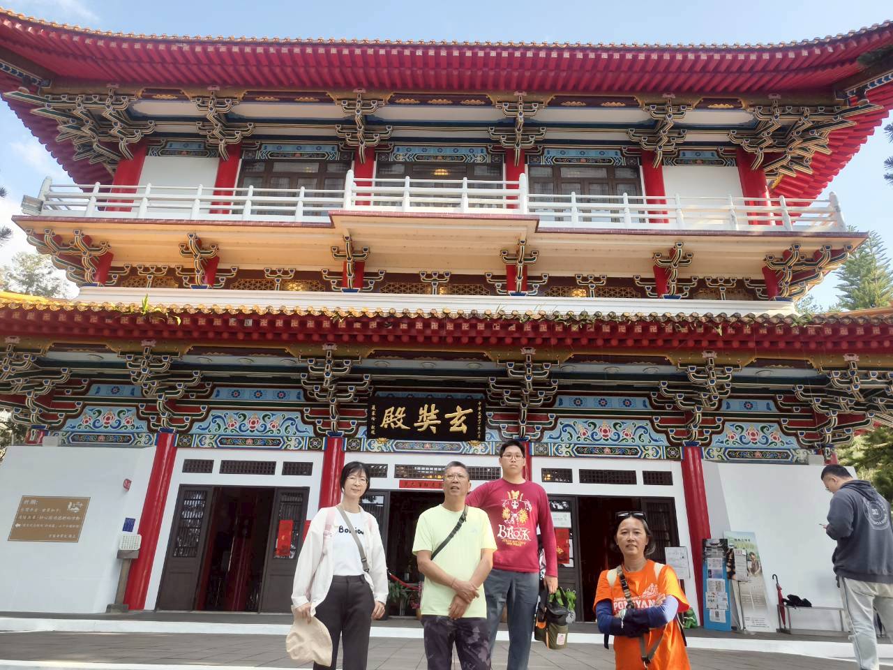 日月潭玄奘寺玄奘殿正面，紅柱紅瓦中式宮殿建築，金色匾額，遊客於殿前合影