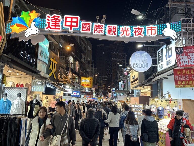 台中逢甲夜市入口拱門，夜晚人潮洶湧燈火輝煌