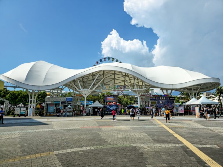 臺北市立兒童新樂園白色波浪造型入口廣場，遠方可見摩天輪