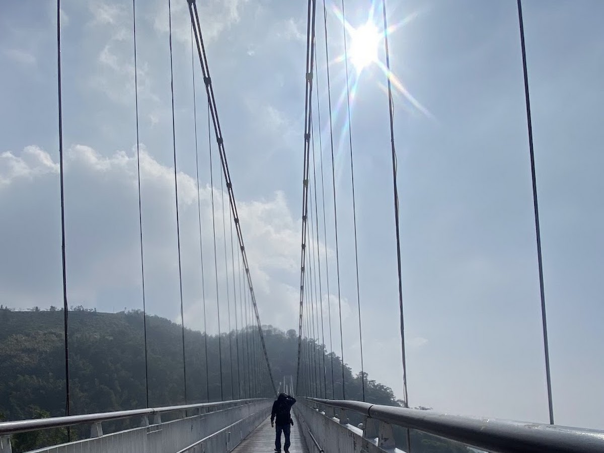 仰角拍攝太平雲梯鋼索橋塔，陽光星芒從頂部射出，藍天白雲