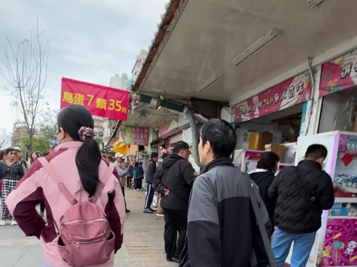 淡水老街攤販旁遊客人潮熙攘