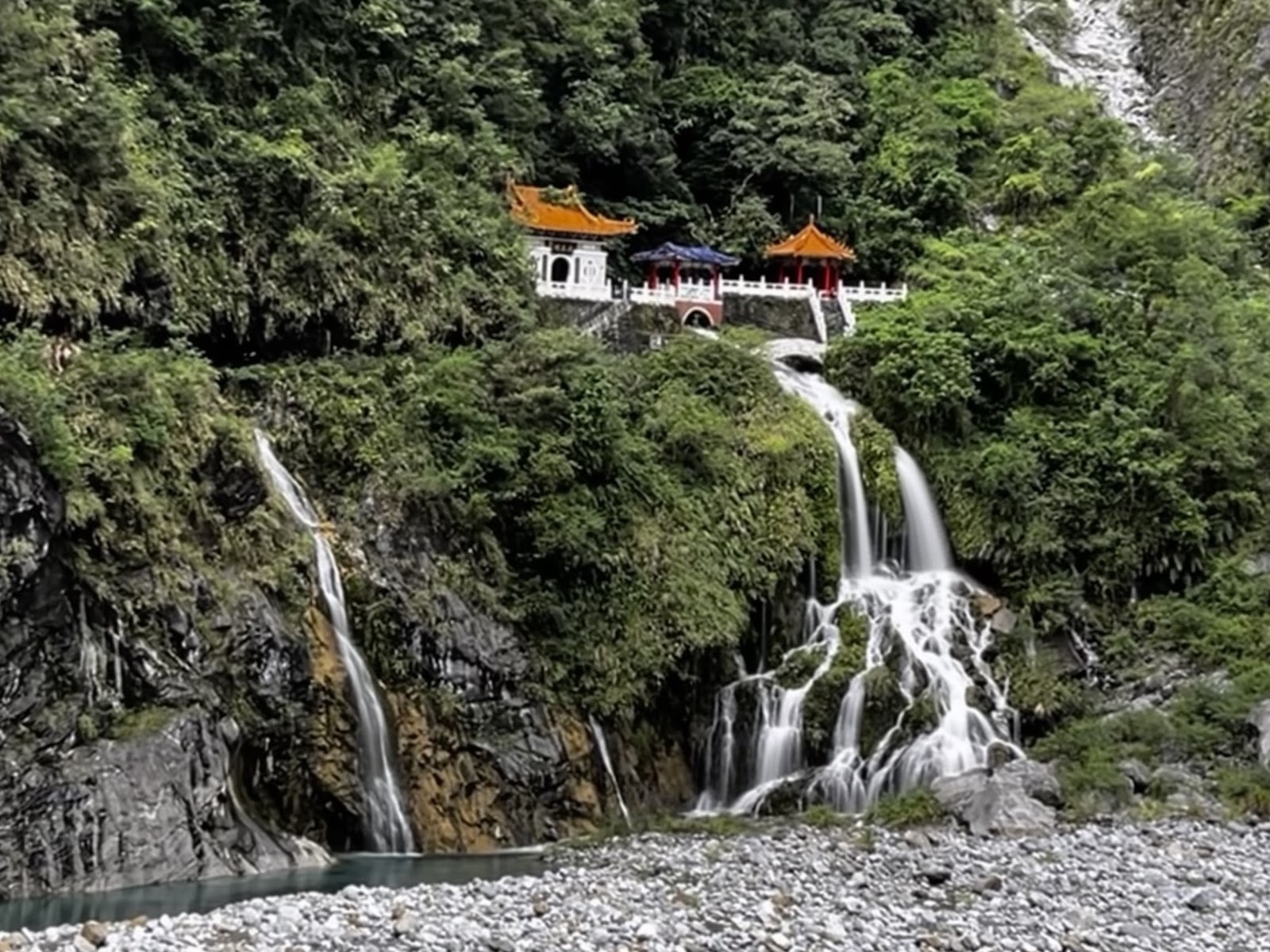 太魯閣長春祠瀑布全景，宮廟建築掩映翠綠山壁，壯闊瀑布傾瀉而下