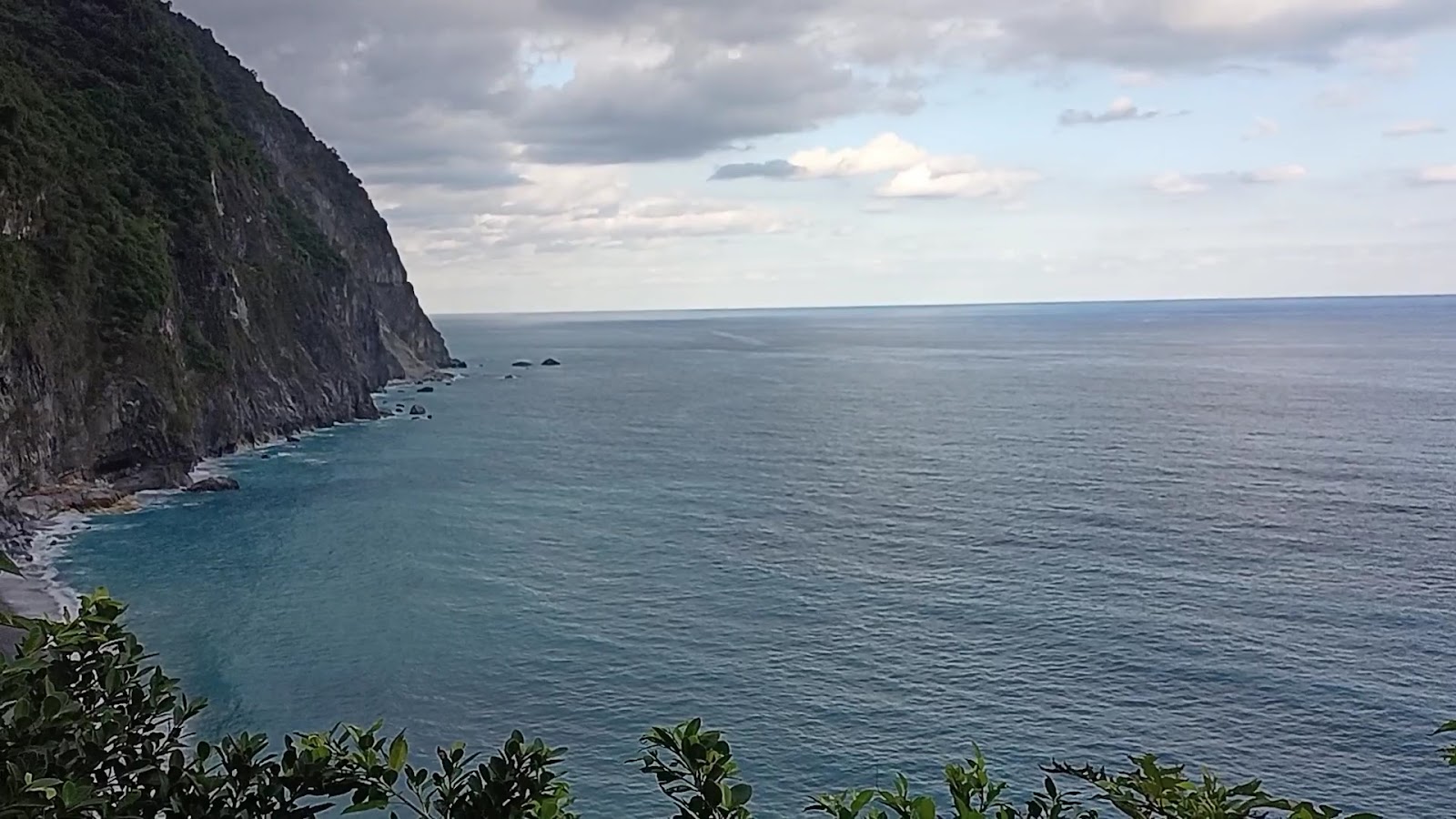 清水斷崖高空俯瞰太平洋，左側蒼翠峭壁沿岸綿延