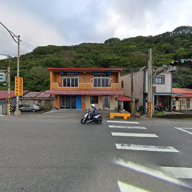 阿強石花菜店面外觀,黃磚兩層樓民宅前有斑馬線與機車