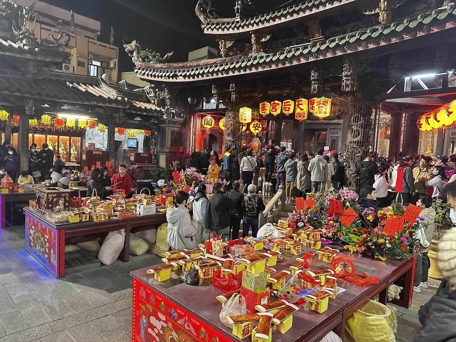 鹿港天后宮夜間祭祀盛況，廟埕供品花籃滿桌