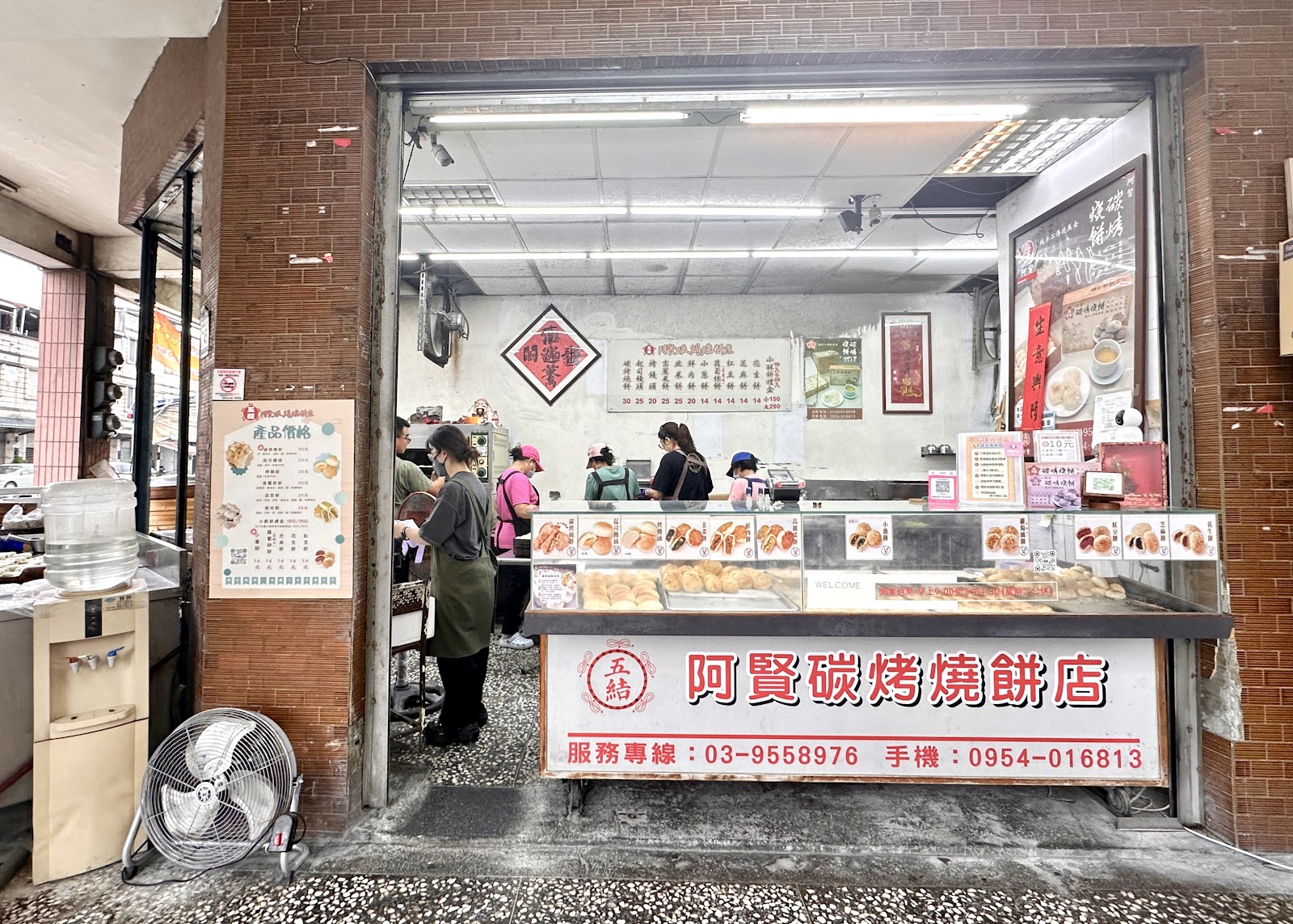 五結阿賢碳烤燒餅店外觀全景，阿賢碳烤燒餅店招牌及玻璃展示台