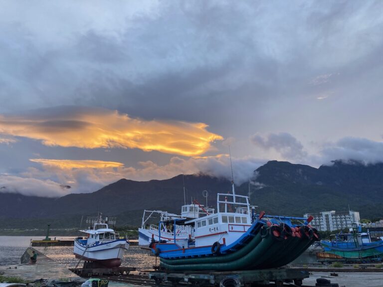 成功新港漁港黃昏漁船停泊，橘紅落日雲彩配山景，海洋之眼台東
