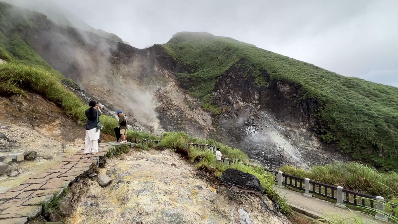 小油坑噴氣孔近景，遊客在木棧道觀察拍照