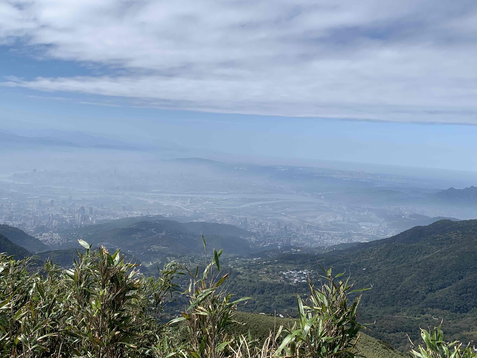 七星山頂俯瞰台北盆地全景，城市隱現雲霧