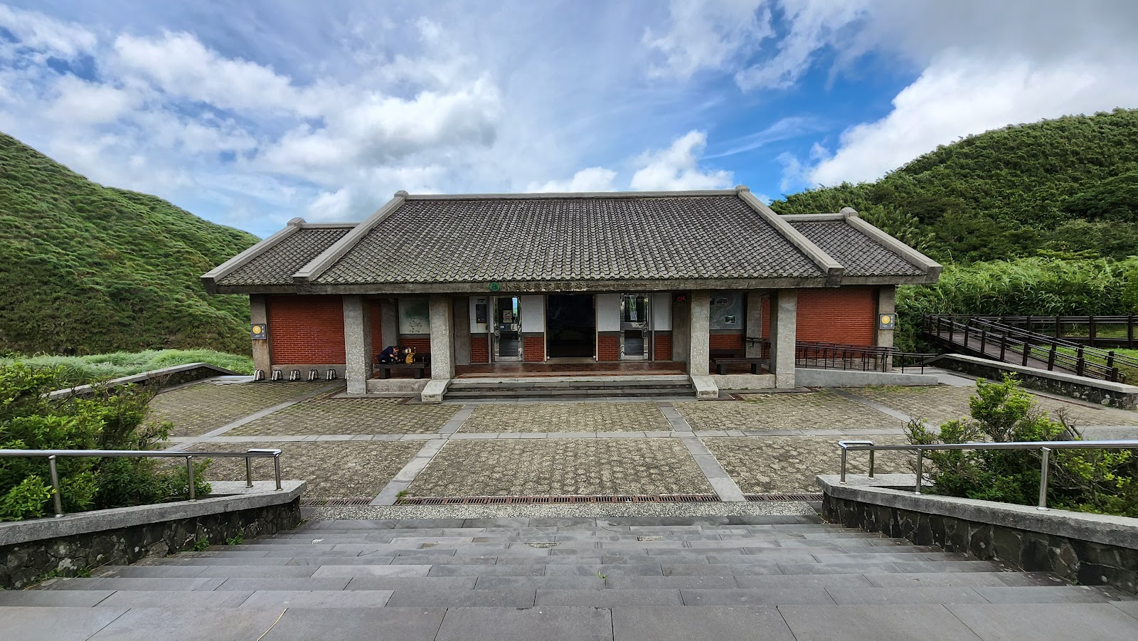 小油坑遊客服務站正面，中式灰瓦大屋頂，紅磚牆