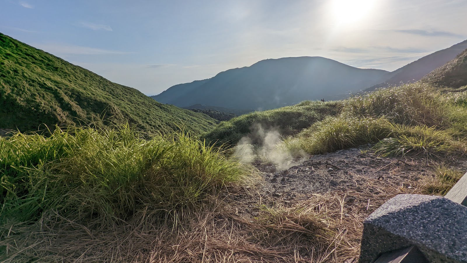 陽明山高山芒草坡逆光金芒，地面硫磺白煙升起