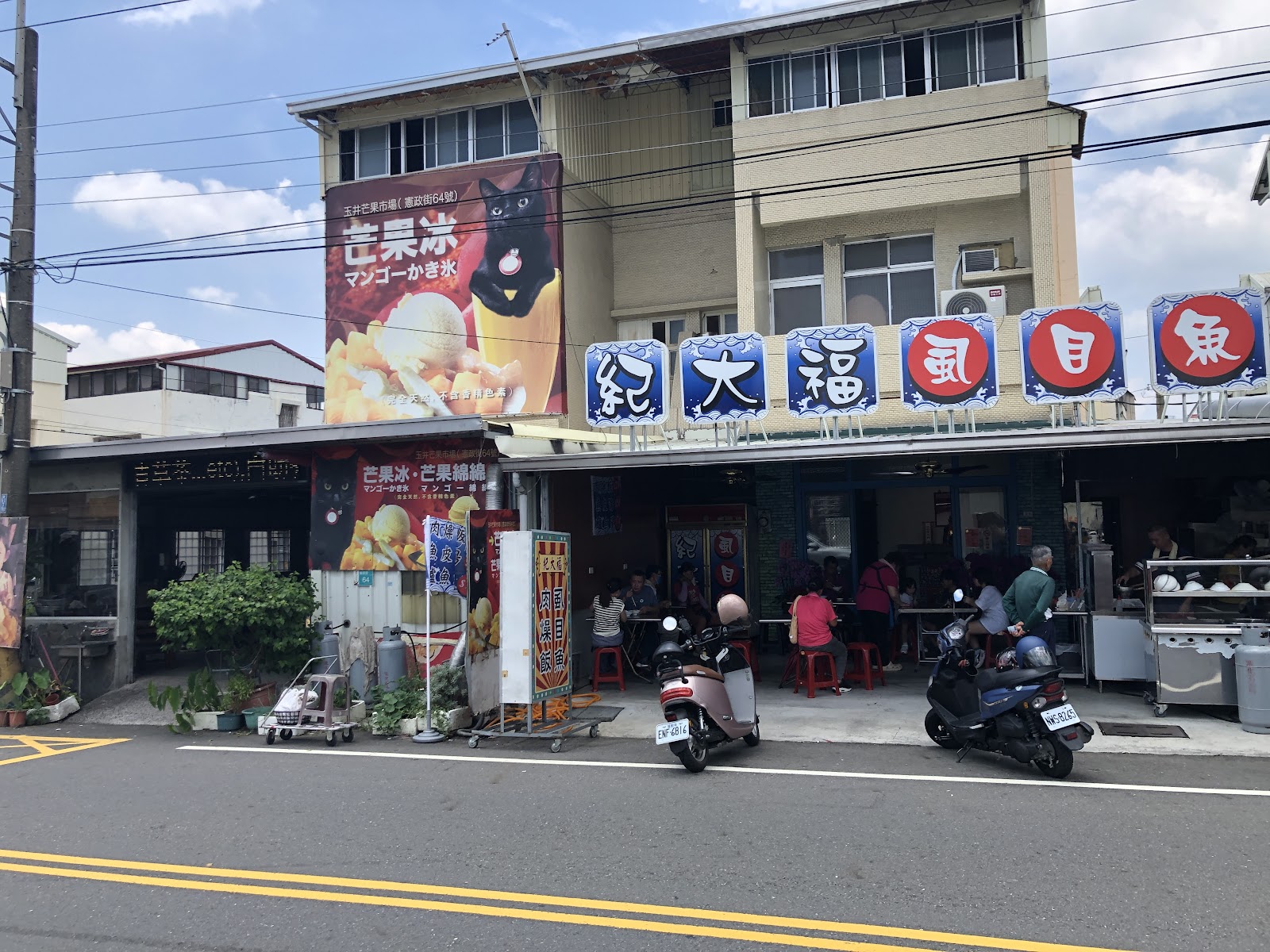 台南玉井街道商店景象，芒果冰廣告大看板與在地餐飲並立展現玉井在地飲食文化