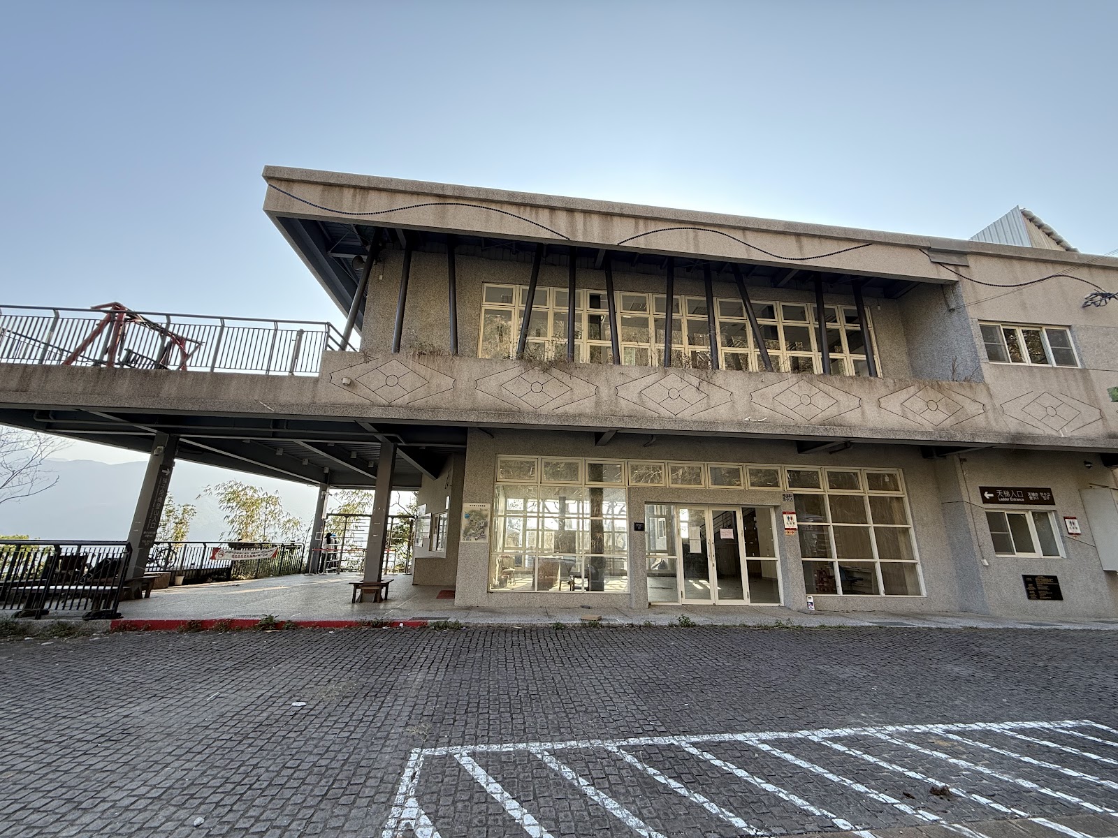 竹山天梯遊客中心建築外觀,兩層樓水泥建築,旁有天橋步道
