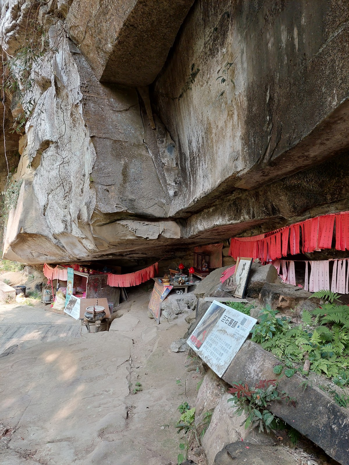 竹山天梯百年土地公廟嵌入巨岩下方,紅布裝飾垂掛,廟宇安靜佇立