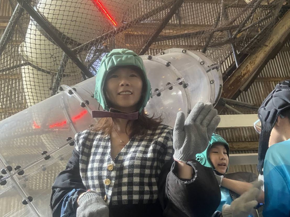 十鼓仁糖文創園區遊客戴頭盔挑戰透明管道溜滑梯廠房背景