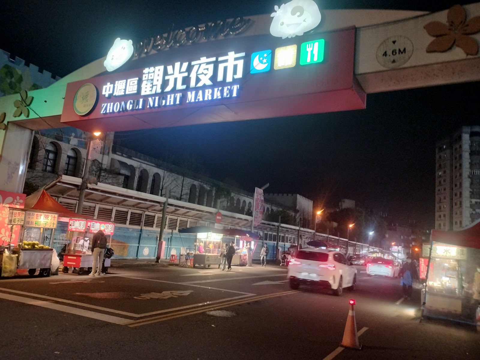 從路口望向中壢觀光夜市入口牌樓，雙語標示