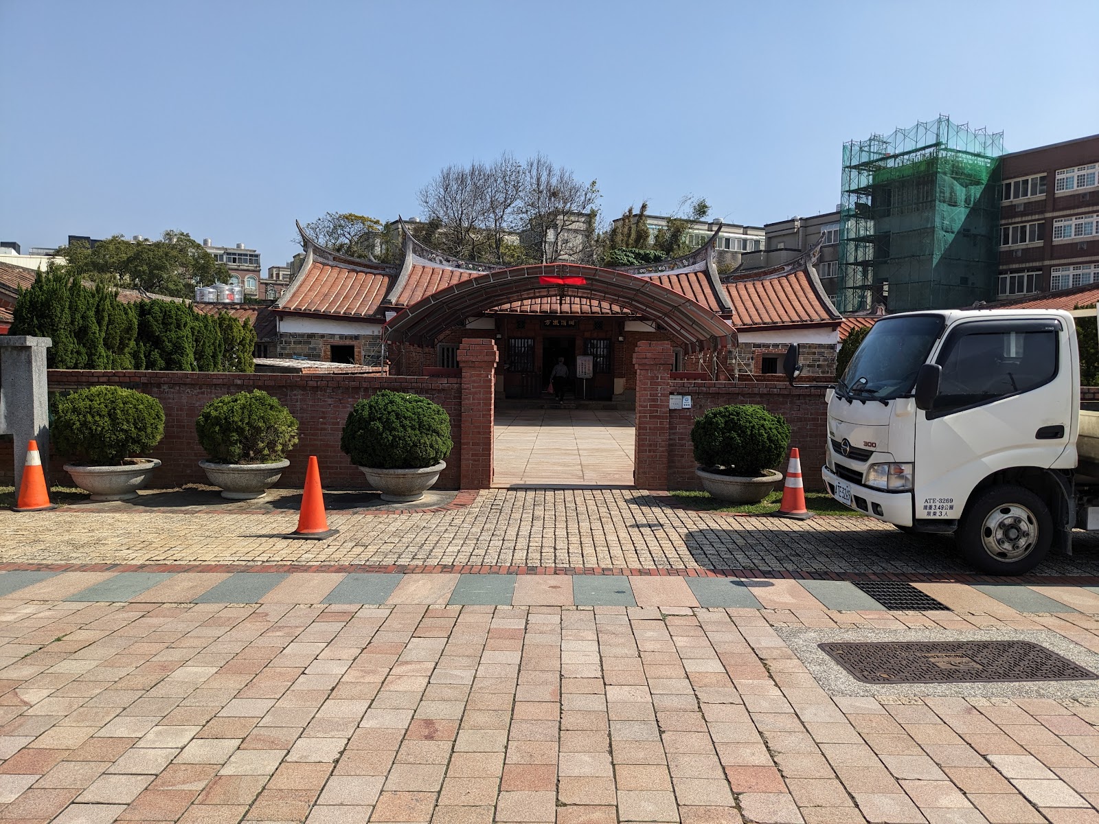 新屋范姜祖堂正門紅磚圓拱入口，兩側整齊圓形灌木，莊嚴典雅