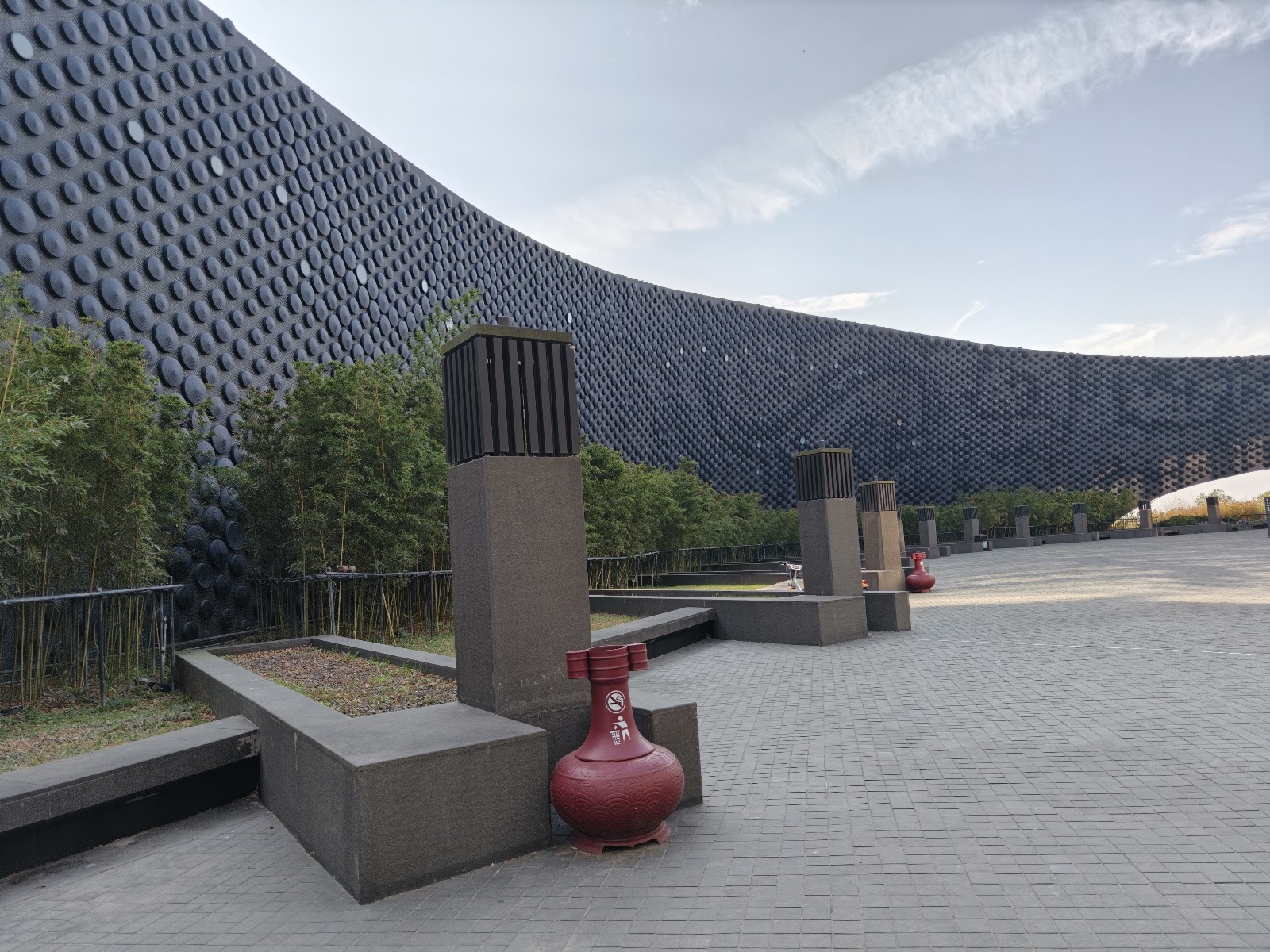 故宮南院主建築外觀，弧形深灰色圓點鋼板外牆搭配竹叢景觀