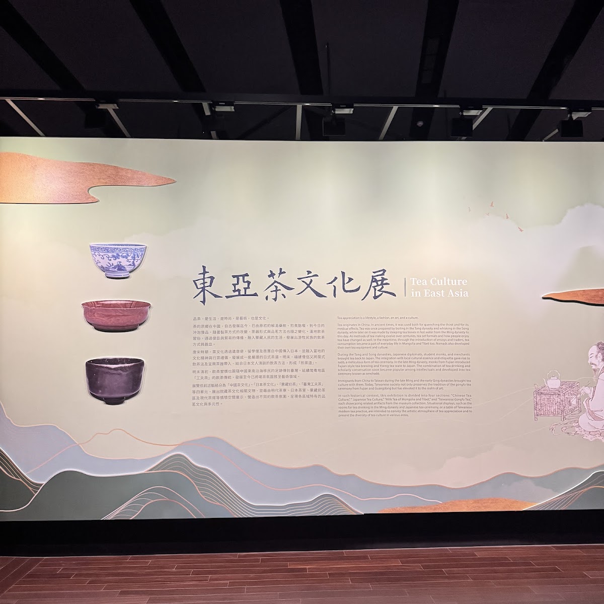東亞茶文化展展廳入口，展示三件茶碗文物，山水畫風設計背景