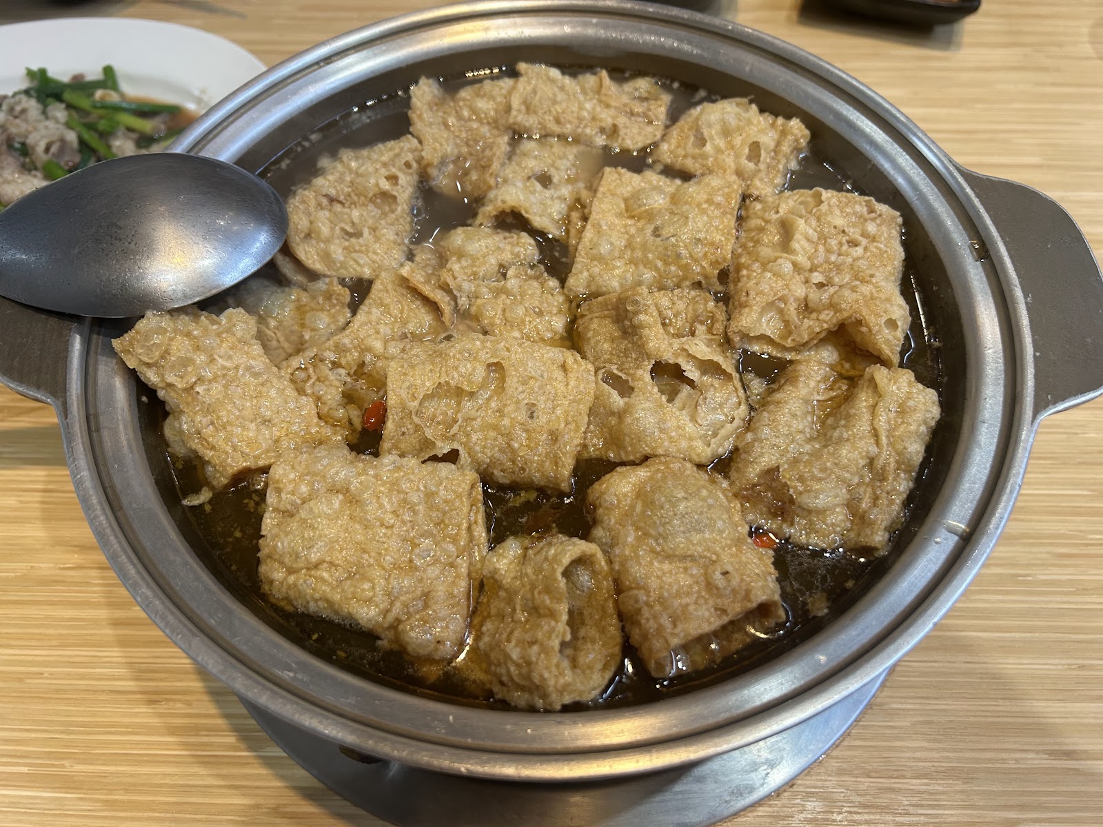 溪湖阿秀羊肉爐，砂鍋裡滿滿酥炸豆皮浸在醬色羊肉湯底