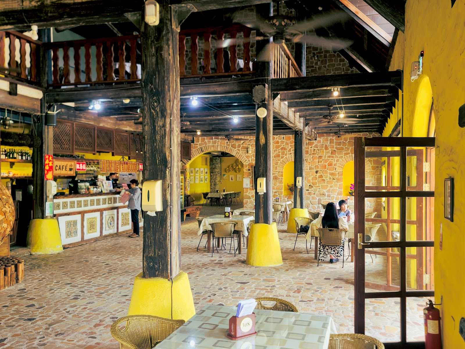 新社莊園城堡酒莊餐廳內部，石牆木梁搭配黃色燈光裝潢