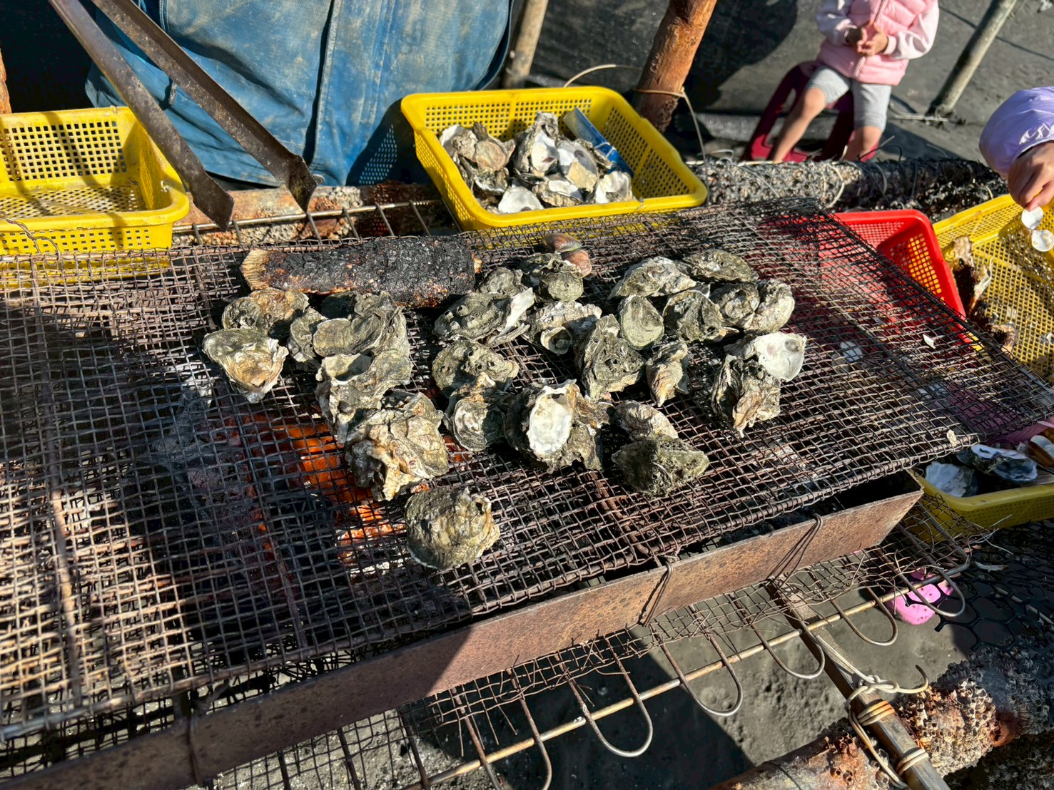 炭火烤蚵仔，炭火明亮橘紅，黃紅籃子擺放整齊