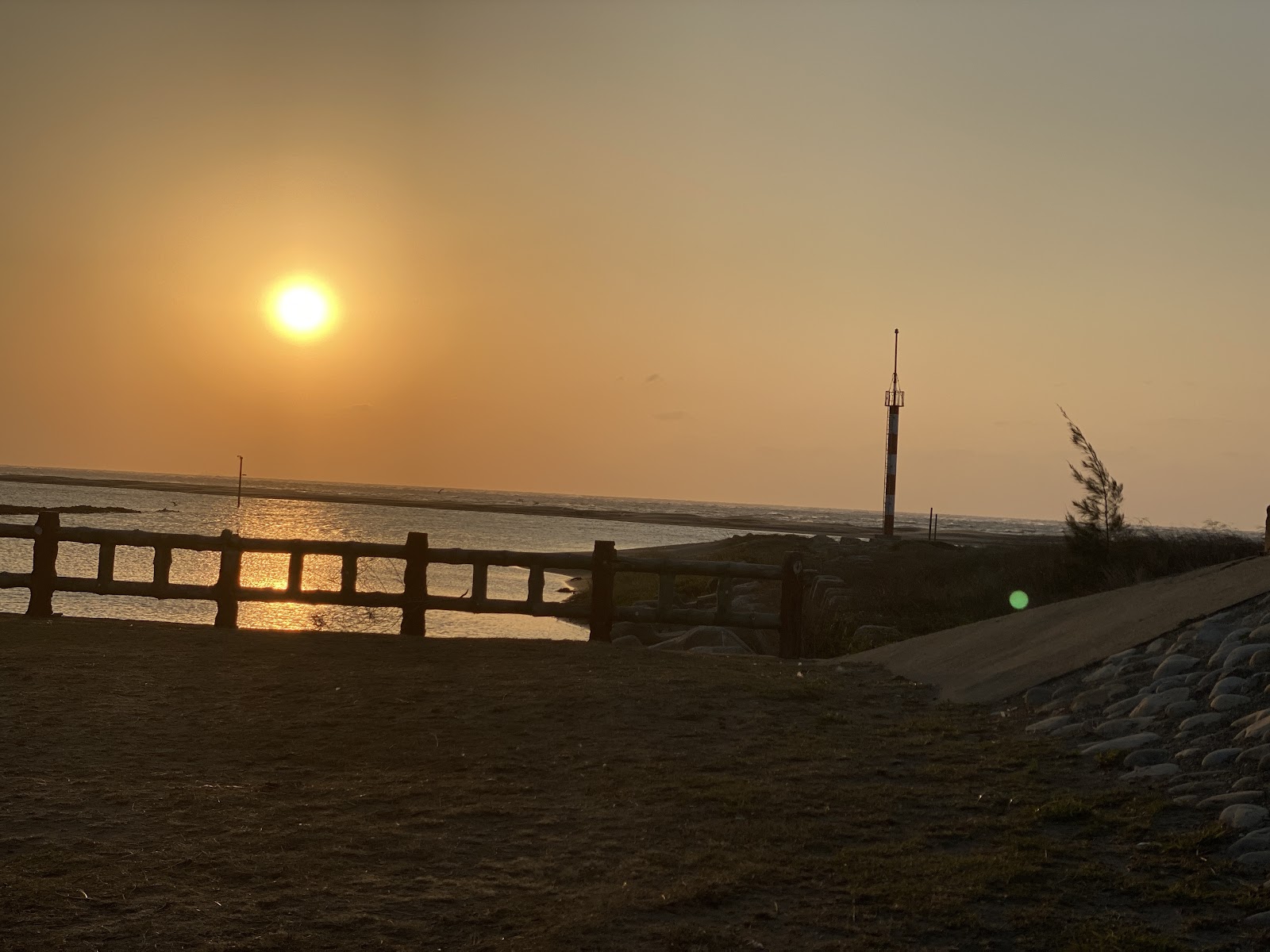 溫寮漁港夕陽直射橙紅天空漁港欄杆剪影堤岸步道
