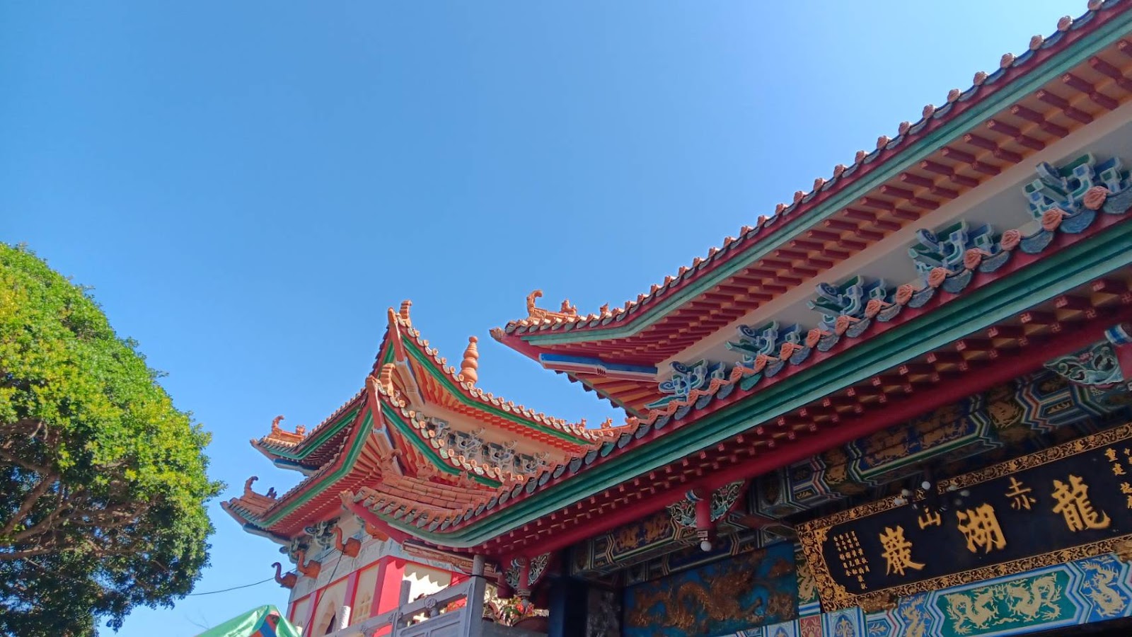 赤山龍湖巖廟頂仰角拍攝,紅色琉璃瓦屋頂層疊,藍天背景