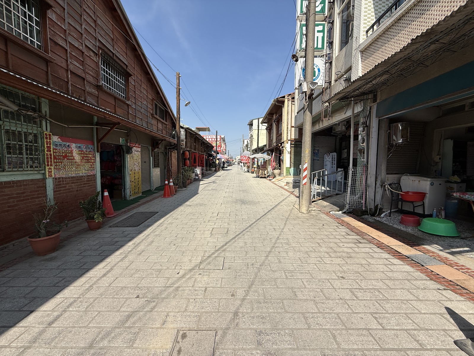菁寮老街步行街中心視角，木造建築延伸至遠方，藍天白雲
