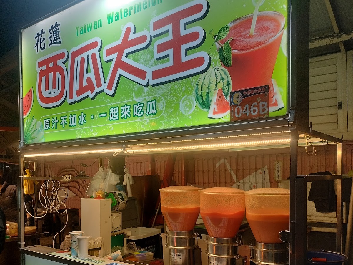 花蓮西瓜大王攤位，招牌碧綠，多台榨汁機現打橙汁