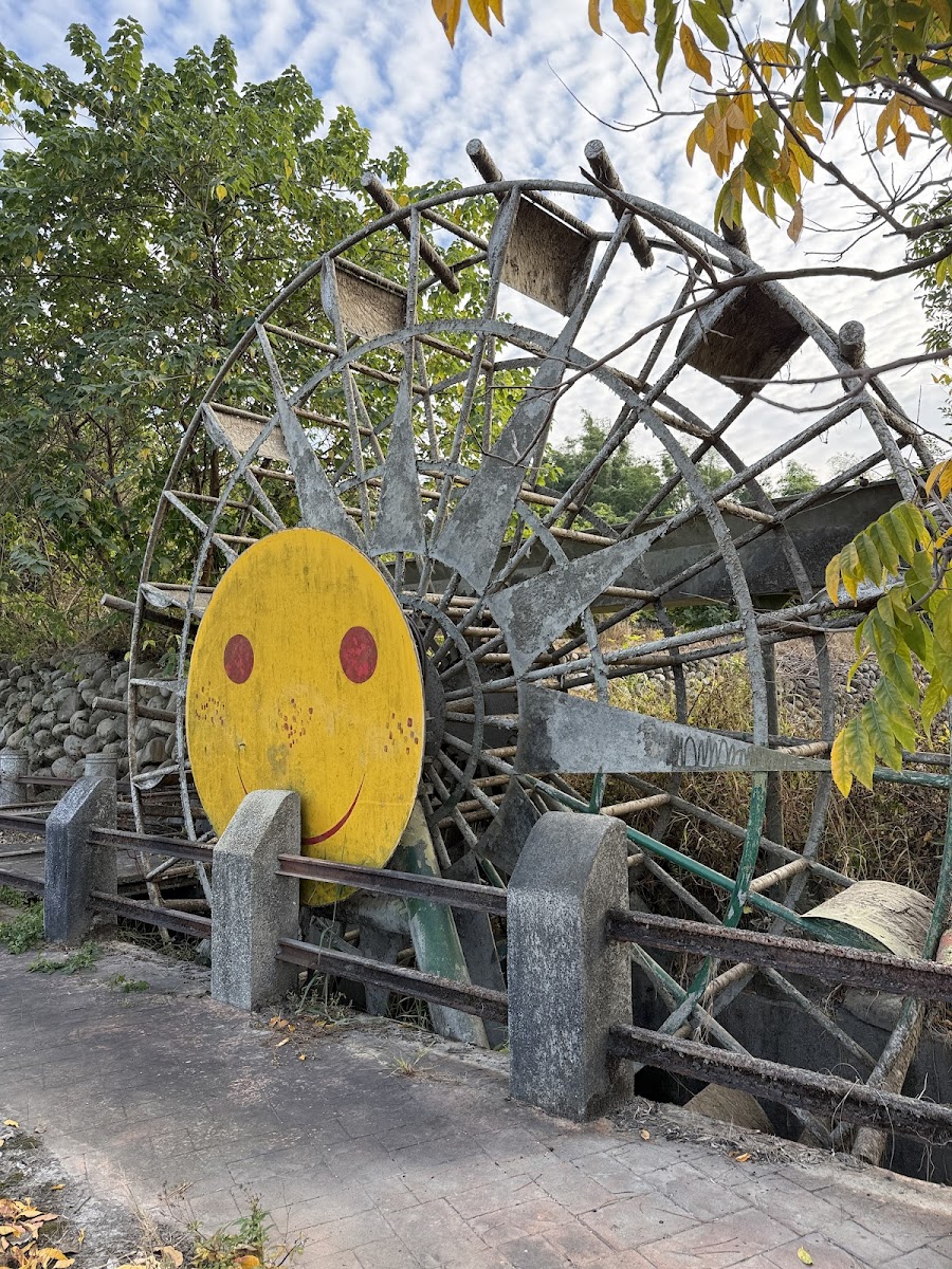 草屯水車公園水車笑臉特寫,黃色圓形笑臉在木構框架中