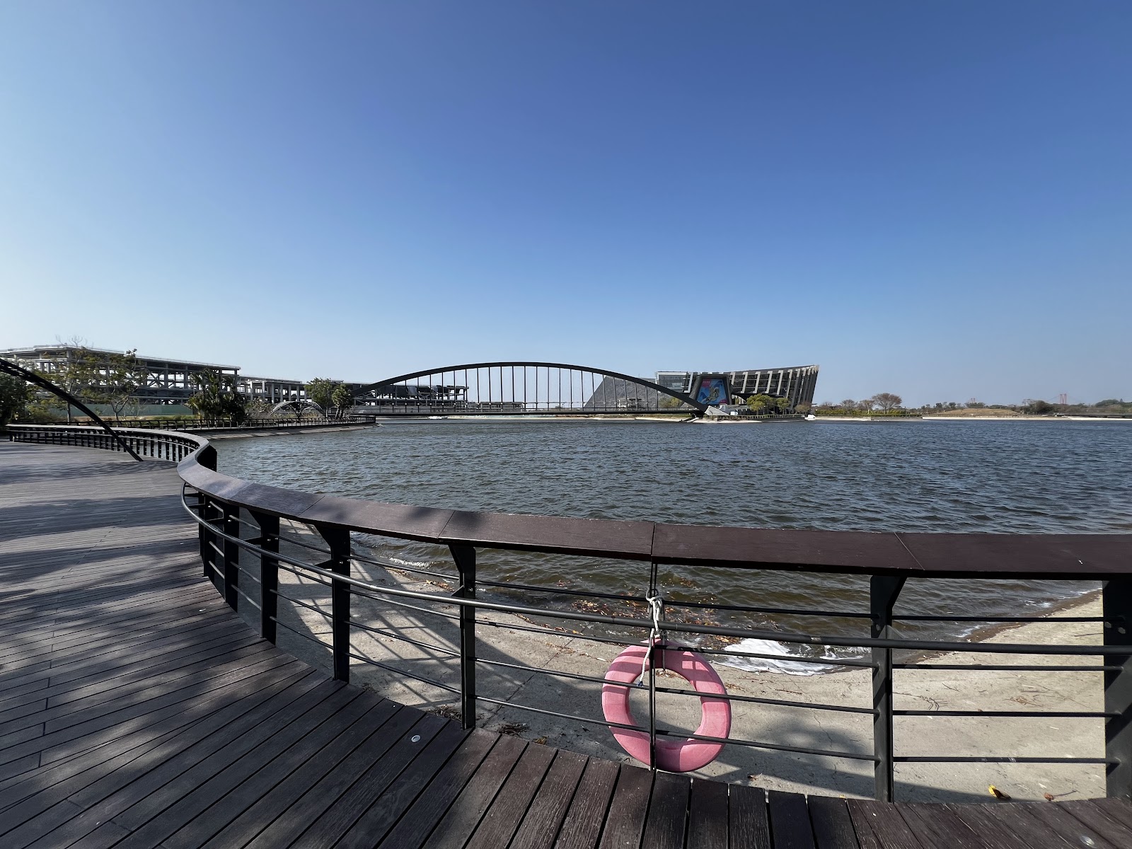 故宮南院湖濱棧道遠眺博物館建築全景，廣闊湖面，木棧道弧形延伸