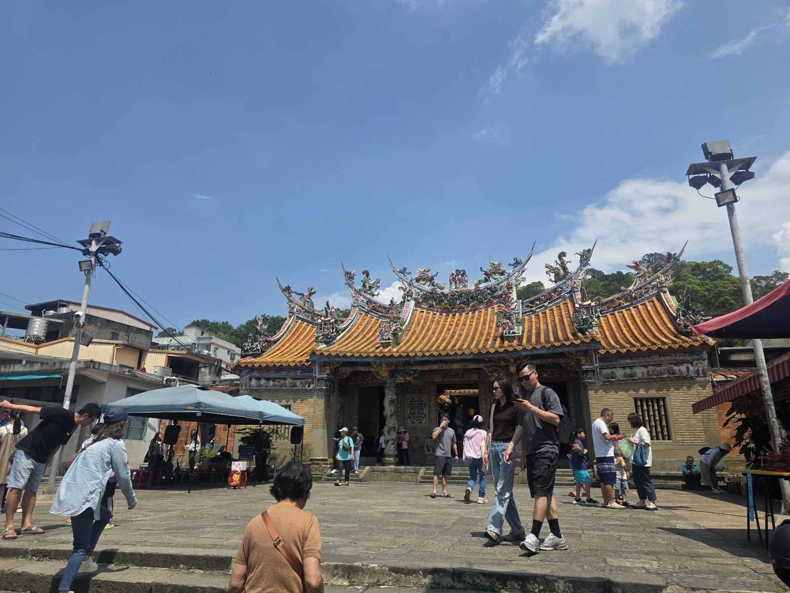 竹東傳統廟宇廣場，黃色屋頂龍飾，陽光下遊客聚集