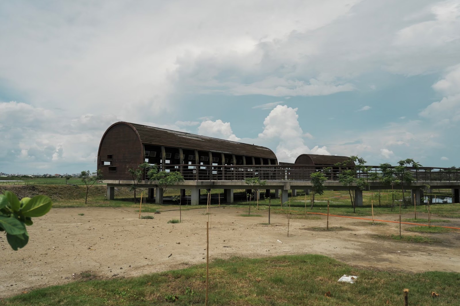 茄萣濕地公園廊道建築白天全景,綠草地與藍天白雲
