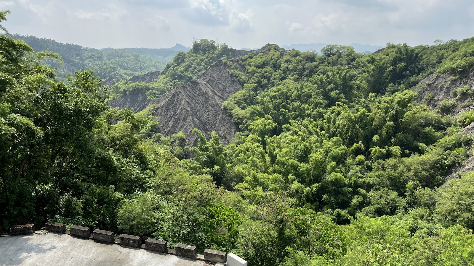 從龍崎牛埔惡地觀景台俯瞰翠綠山谷與裸露泥岩山脊遠景