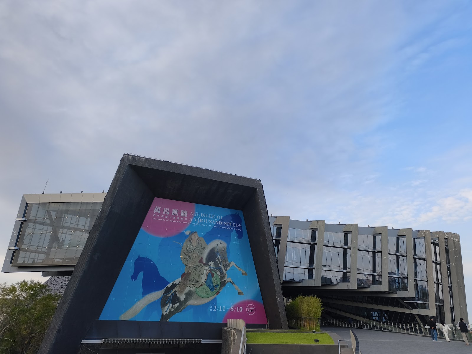 故宮南院特展招牌，萬馬歡騰特展藍色海報，背景博物館建築