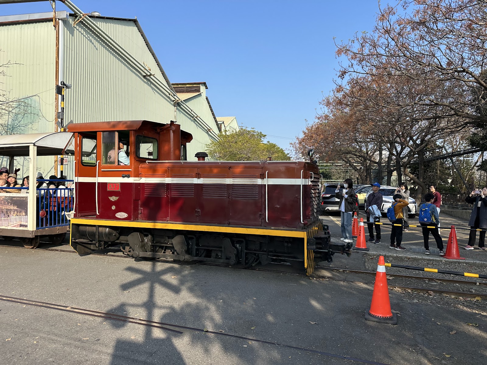 溪湖糖廠紅色五分車車頭側面，遊客在旁拍照留念