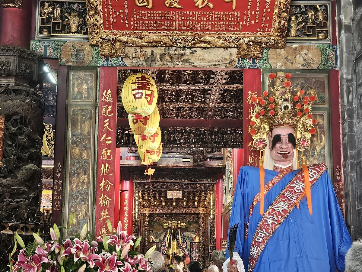 西港慶安宮刈香期間神將表演,身著藍色長袍,站立於正殿神龕前