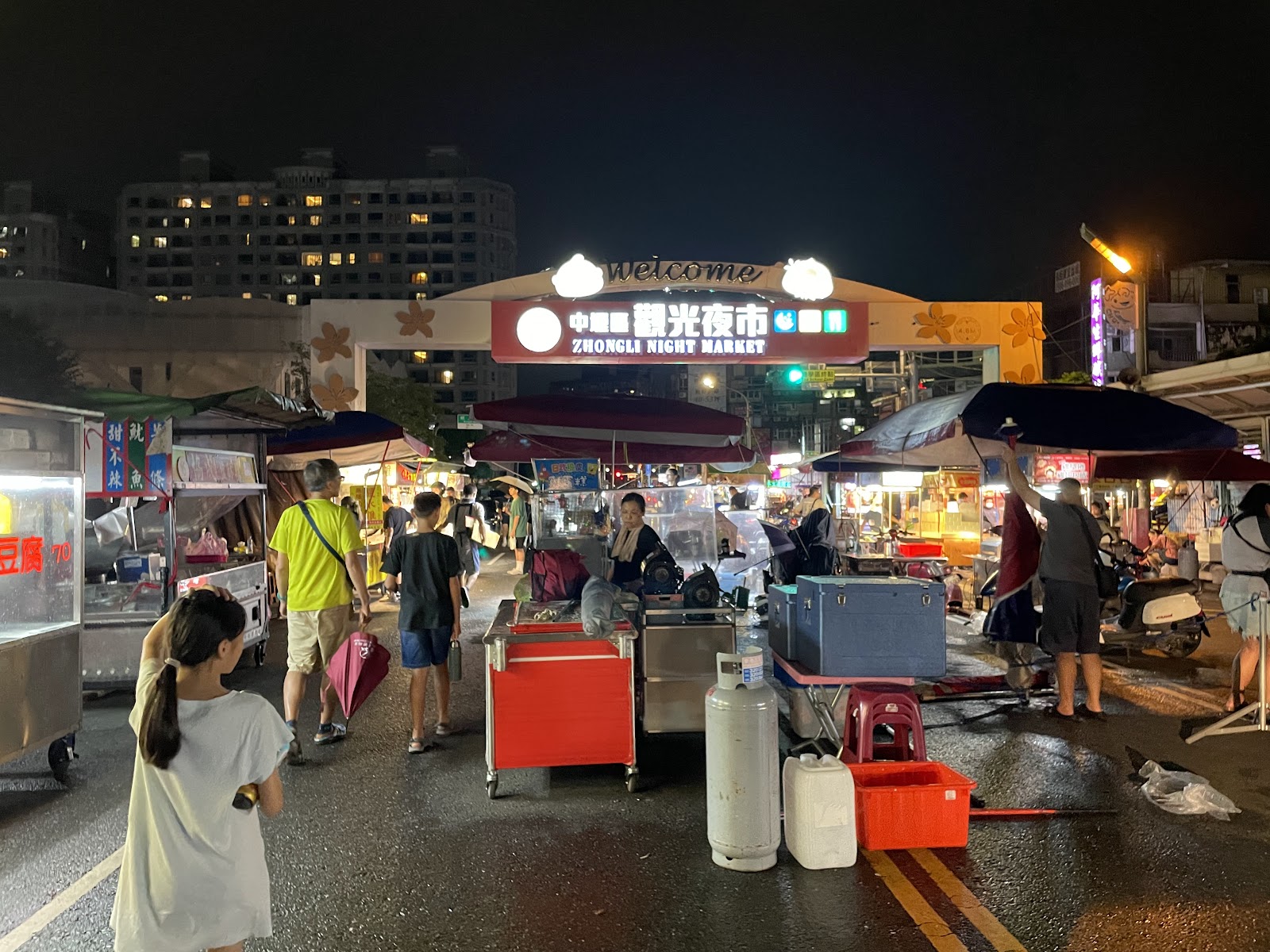 中壢觀光夜市雨天攤位，遊客持傘逛街，依舊熱鬧