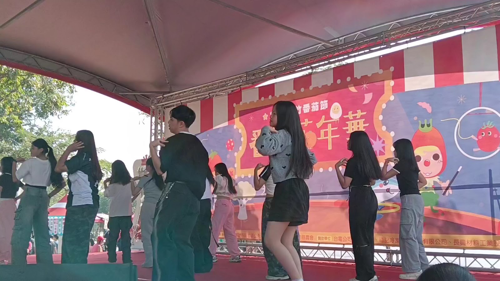 路竹番茄節在路竹體育園區舉辦,舞台上多名青年正在表演舞蹈,背景是路竹番茄節橫幅