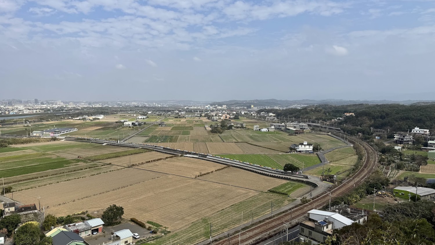 農田間行駛的列車與遠方山景