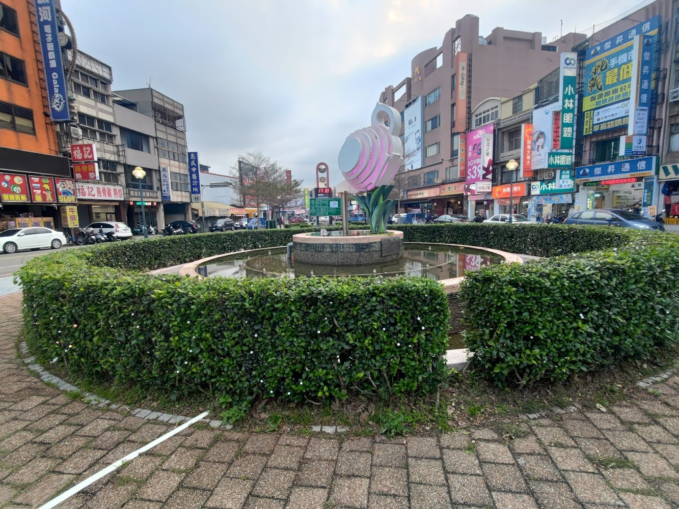 上公園圓形小廣場雕塑與商圈街景