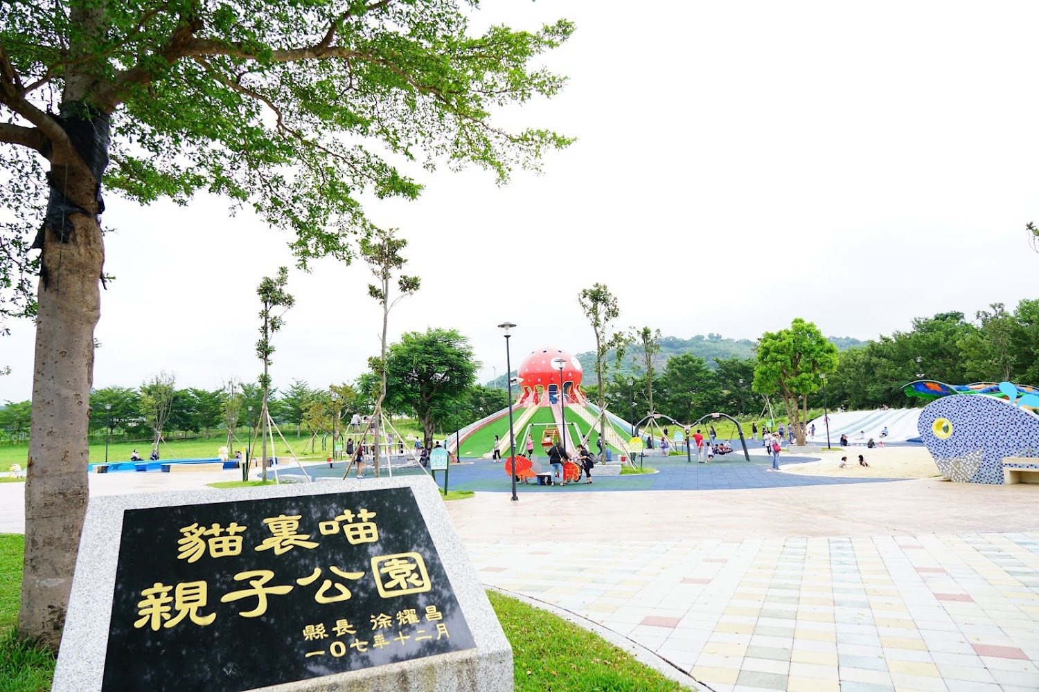 公園全景，可見溜滑梯、攀爬區與沙坑。