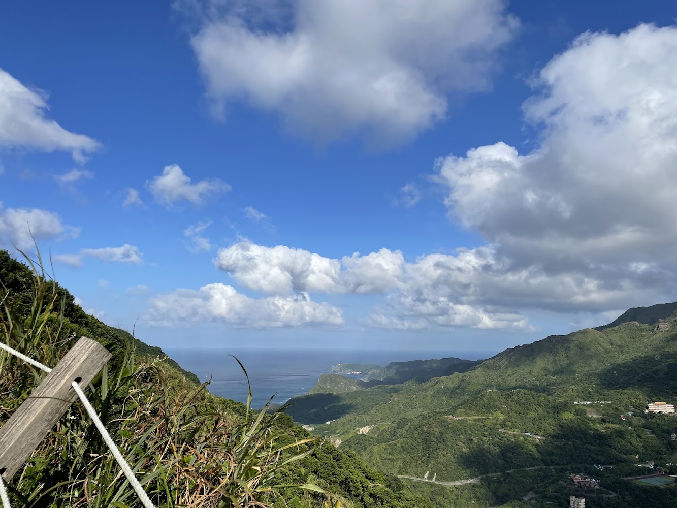 青翠山谷藍天白雲與遠方海洋