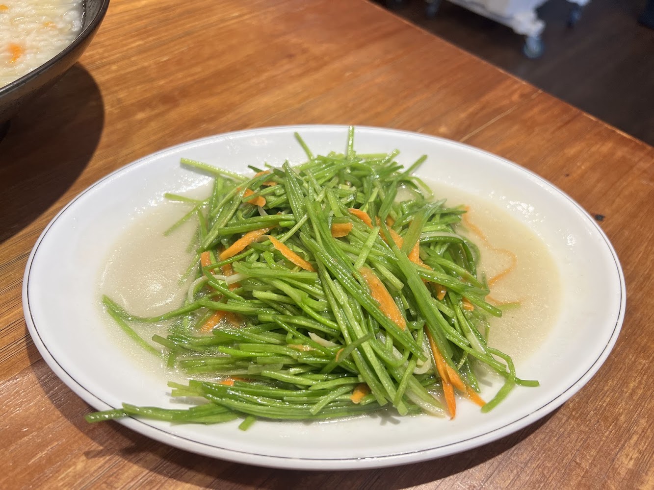 清炒龍鬚菜與白粥的小餐桌畫面