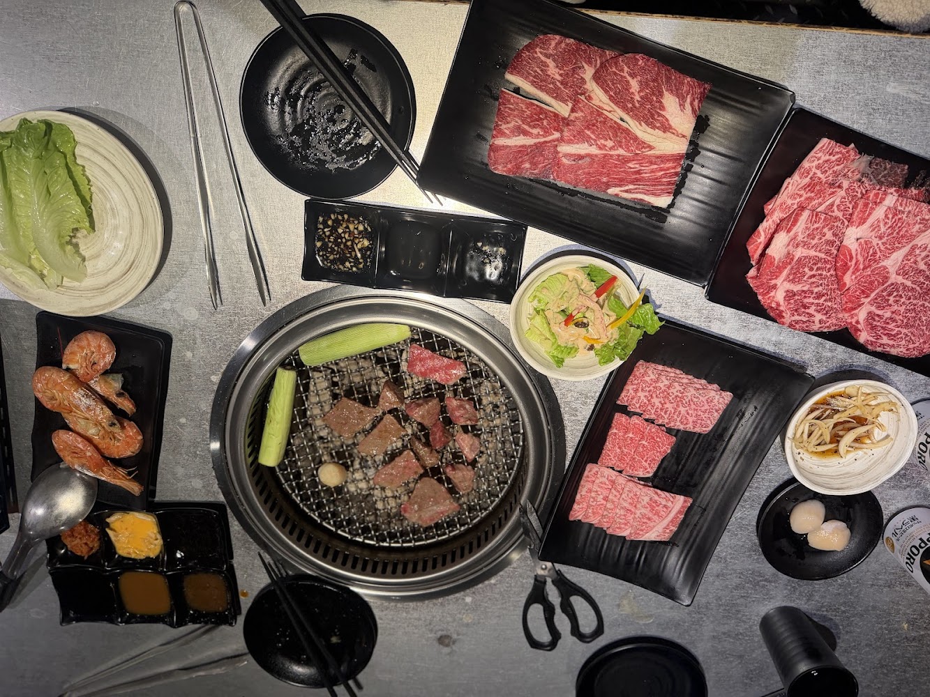 三柒燒肉專門店中壢店桌面有多種牛肉蝦子干貝與烤爐