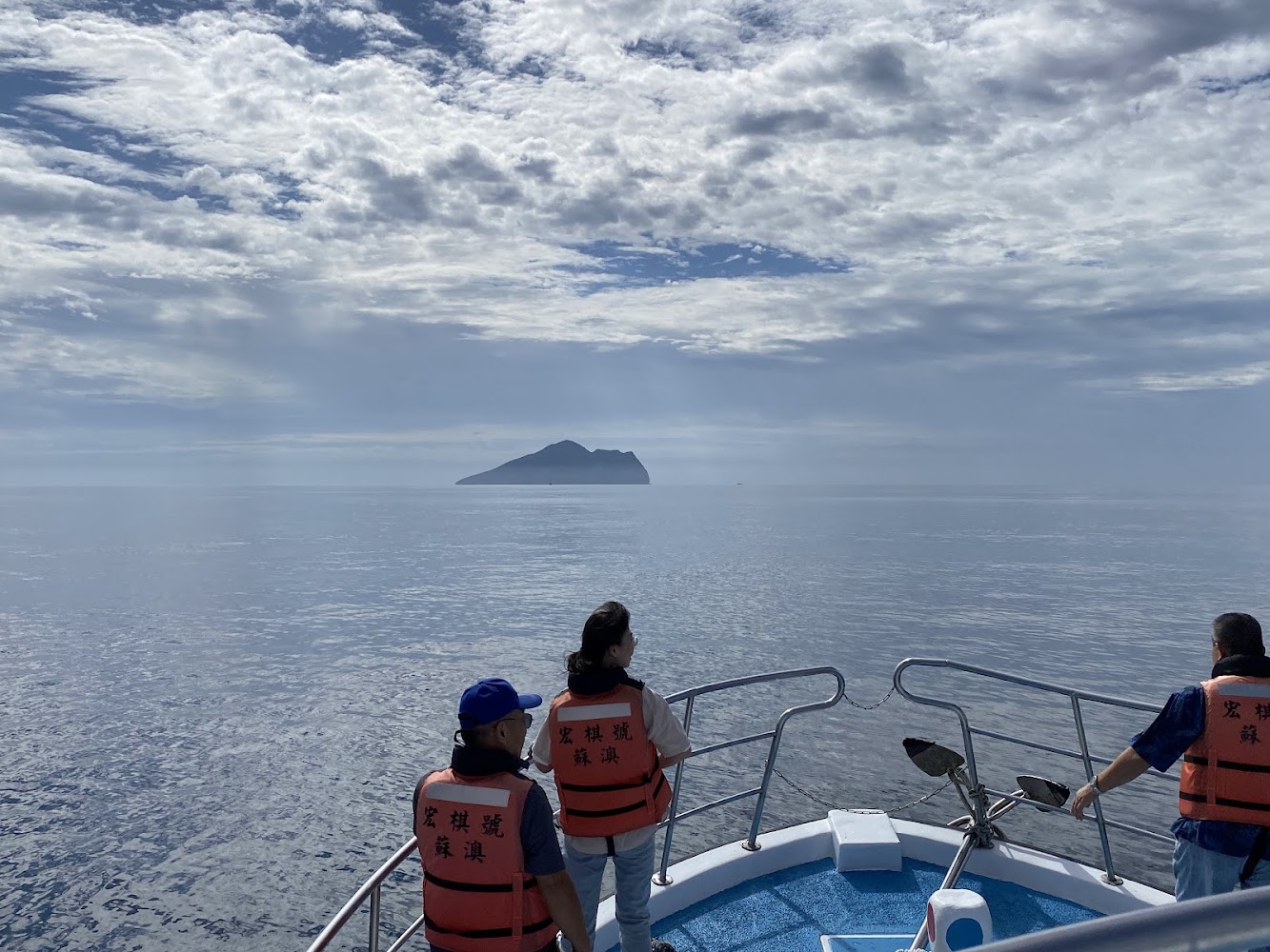 船上旅客穿救生衣遠眺海上島嶼