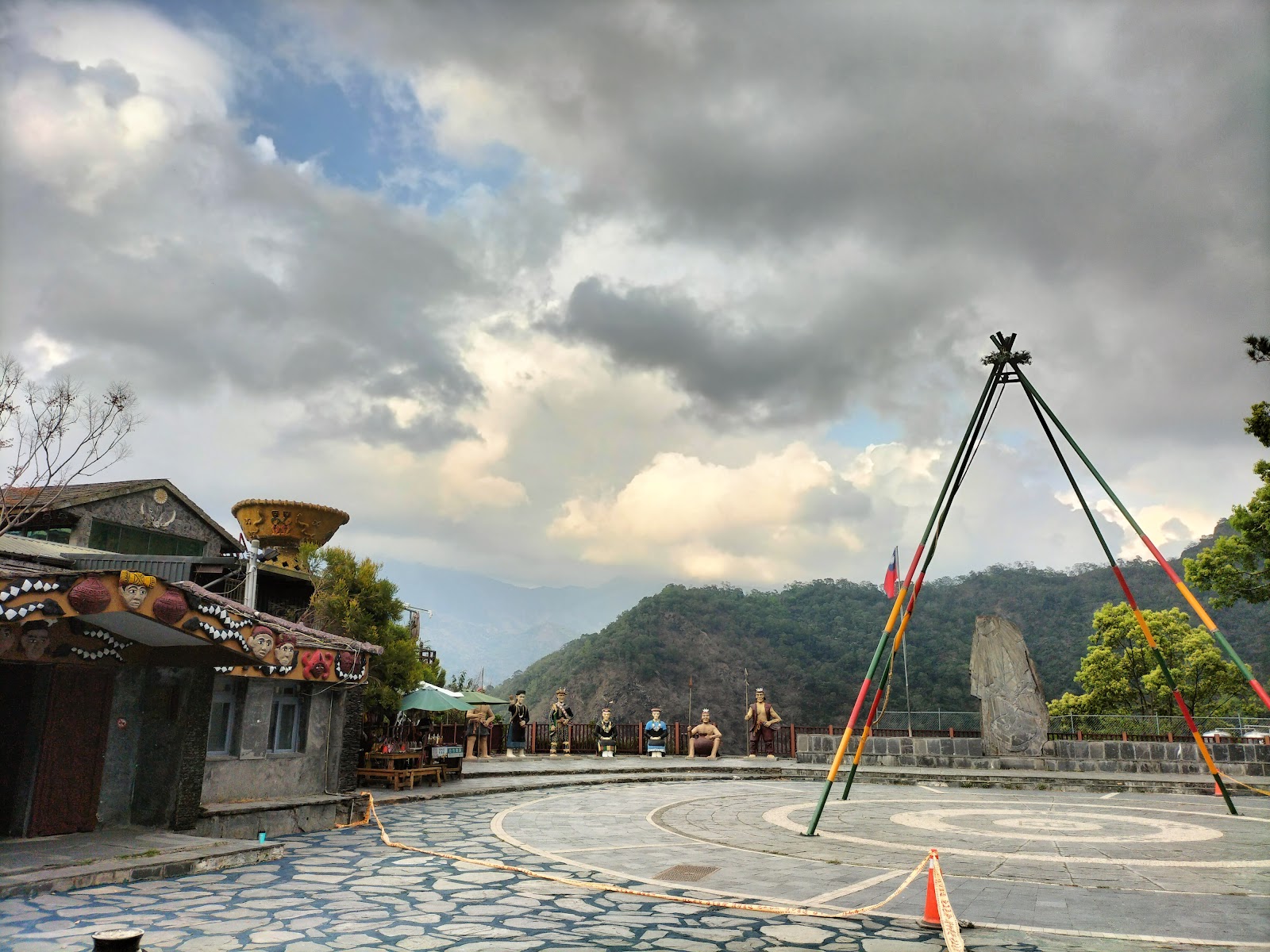 岩板巷廣場掛滿彩旗,天空陰雲密布,山巒環繞