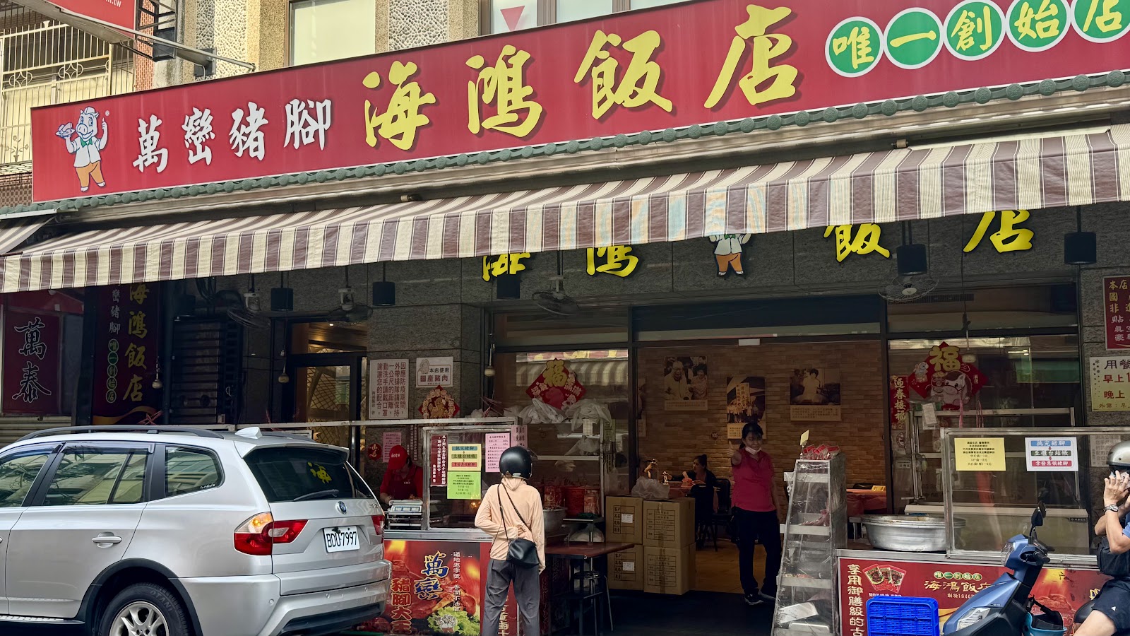 萬巒豬腳街景，海鴻飯店紅底金字招牌，顧客大排長龍